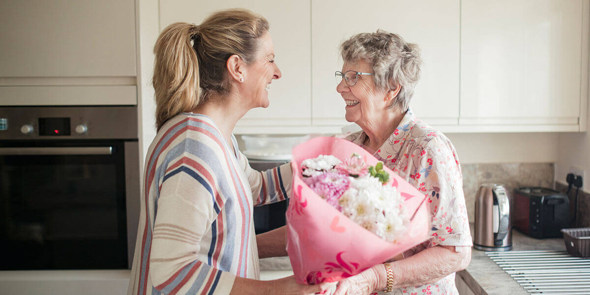 Caregiver handing client flowers